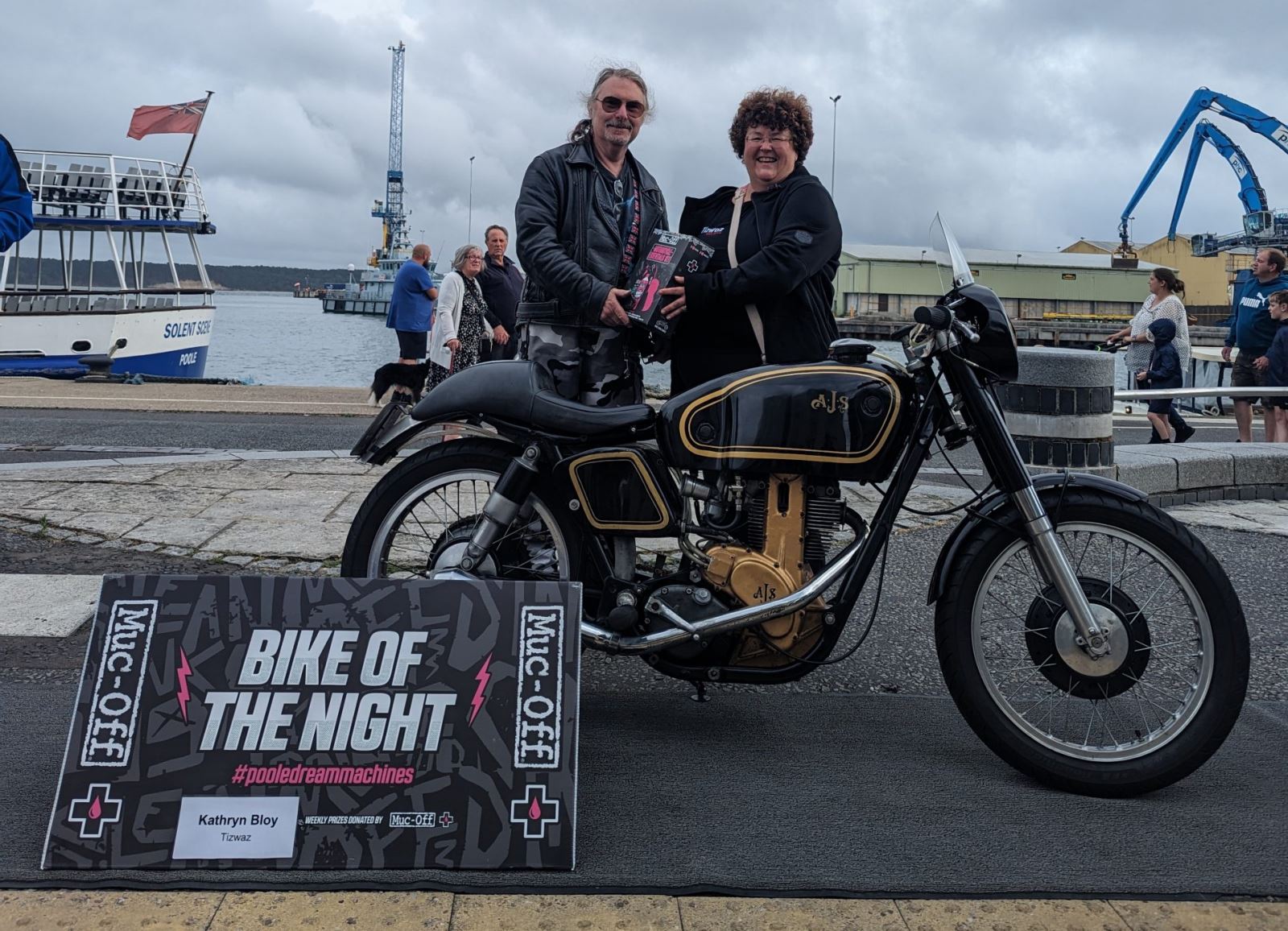 Man named steve accpeting his award for bike of the night at a grey and rainy Pooel quay
